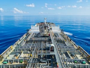 Oil tanker steaming through calm blue open sea.